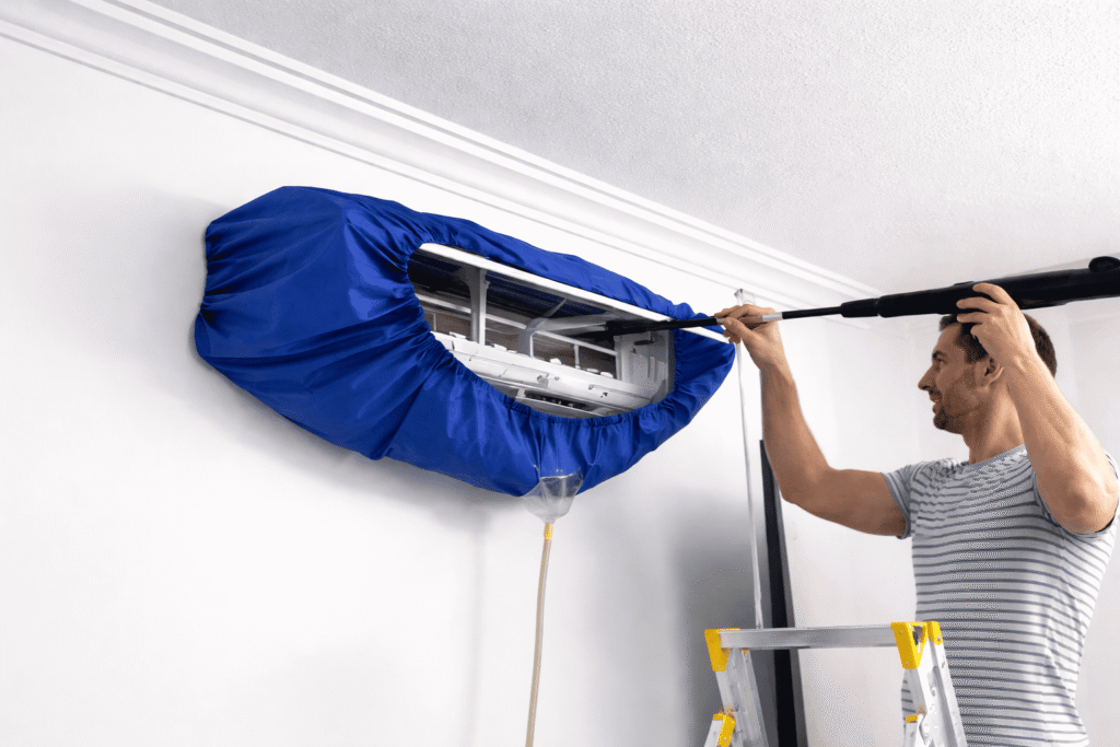 Technician cleaning a split air conditioner indoor unit